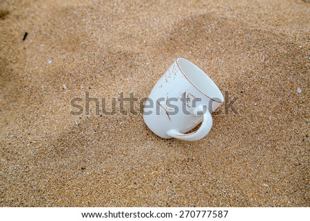 Concept for relaxation, coffee mug in sand