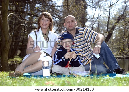 Happy parents and son having picnic in park