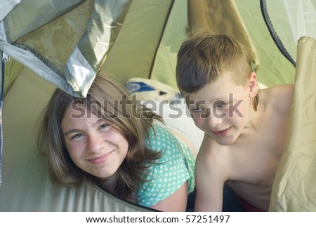 Family camping in tent in woods