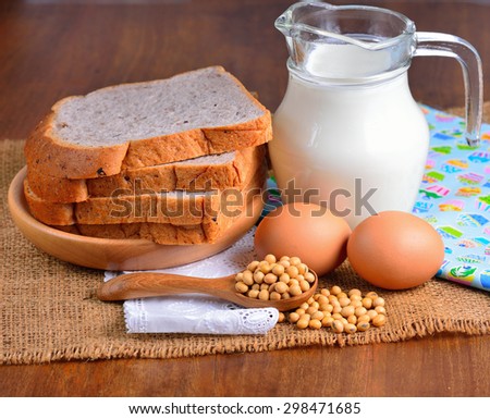 eggs ,soybeans ,milk and bread on wooden background.