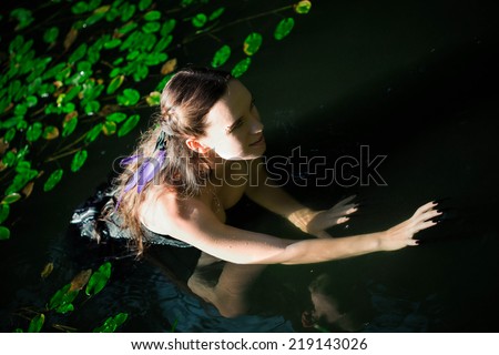 mermaid with long hair and long black nails sneaks in water