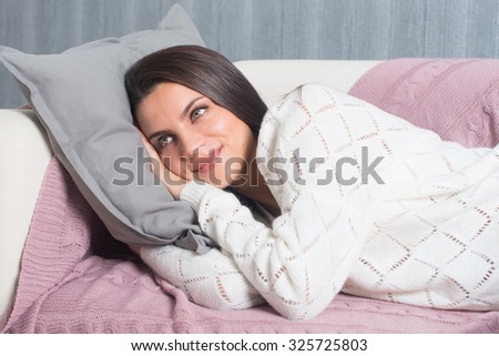 Relaxing at home, comfort. cute young woman smiling, relaxing  on white couch, sofa  at home.