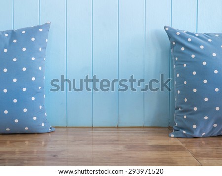 Blue wooden wall background with polka dot pillows on wooden bench (Composition and space for text)