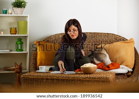Brunette woman relaxing in living room with Siberian Husky