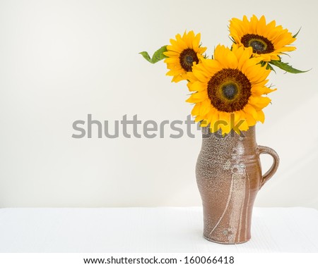 Arrangement of sunflowers in a salt-glazed jug, made by British craftsman Michael Casson