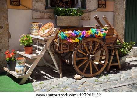 typical portuguese ceramics and small old wooden cart at the doors of a craft shop in Lisbon, Portugal