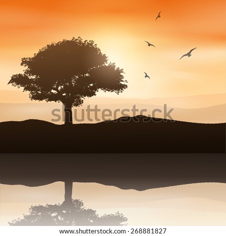 Silhouette of a tree against a sunset sky reflected in water