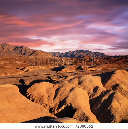 A Desert Highway Traversing The Bizarre Mars-Like Landscape Of Heavily Eroded Ridges At Zabriskie Point, Death Valley National Park, California, USA