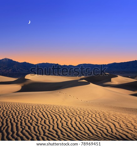 Early Morning Sunlight Merges With A Twilight Moon Over Sand Dunes And Mountains At Death Valley National Park, California, USA