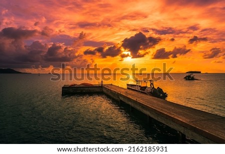 Wooden sea pier at sunset. Boat at sea pier at sunset. Orange sunset over sea pier. Pier boat at sunset sea Foto d'archivio © 