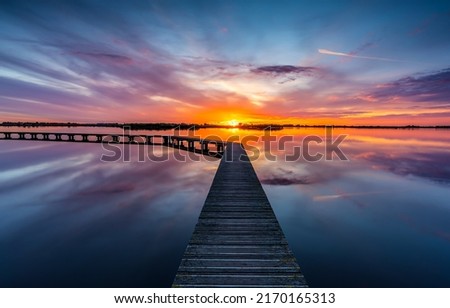 Lake pier at dawn landscape. Lake pier at dawn. Beautiful sunrise over lake pier. Lake pier at dawn landscape Foto d'archivio © 