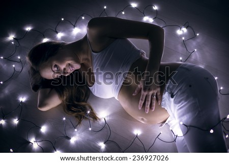 beautiful pregnant girl with Christmas flashing lights, beautiful portrait image