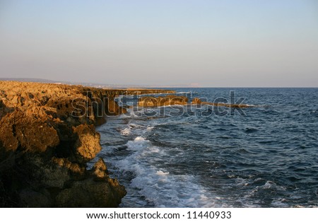 Cyprus, coast from the cooled down lava with waves.