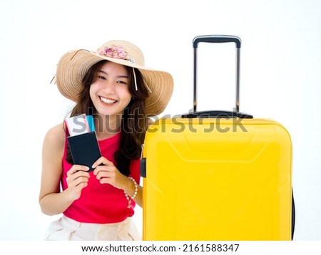 Beautiful happy Asian woman in pink sleeveless shirt and beach hat smile and holding passport, flight ticket and yellow suitcase isolated on white background. Young traveler or tourist ready to trip. ストックフォト © 