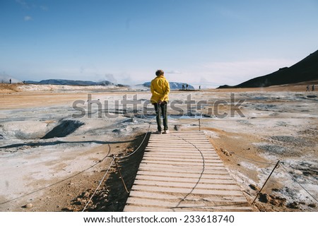 man standing in the field in the middle of increased volcanic activity area