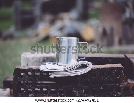 Frothing milk pitcher on the cloth napkin on the old red bricks