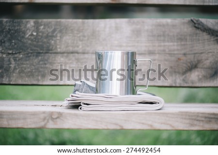 Frothing milk pitcher on the cloth napkin on the wooden background