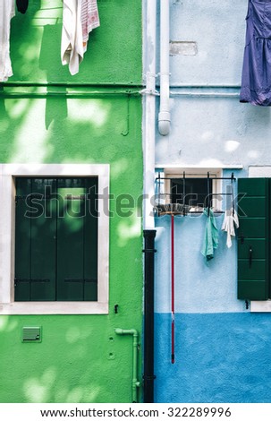 Beautiful house facade on Burano island, north Italy. Colorful half green,half blue house wall with a door and some windows