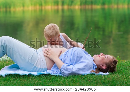 Little boy 2-3 yo kissing his pregnant mother