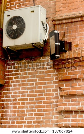 Air conditioning heat pump mounted on old brick wall
