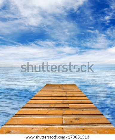 wooden pier on sunny day with white clouds and sun