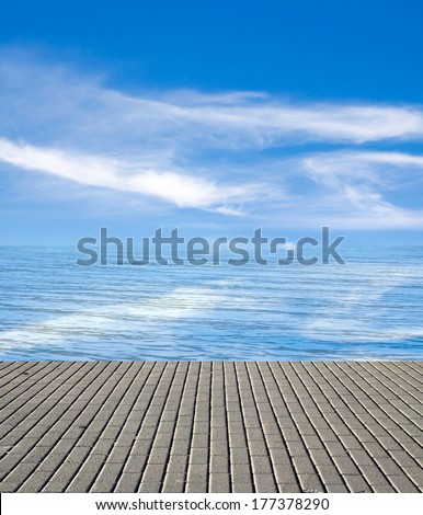 concrete pier on the sea and sky with clouds