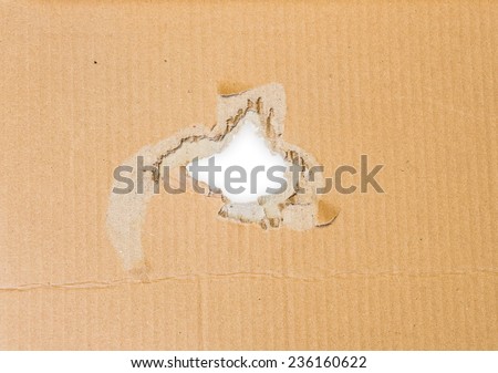 Torn hole in cardboard paper