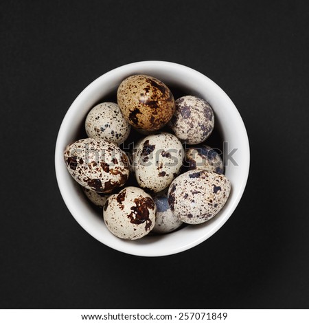 quail eggs in a bowl selective focus with shallow depth of field on a black background