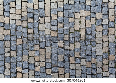 Stone pavement texture. Granite pavement background. Abstract background of old cobblestone pavement close-up.