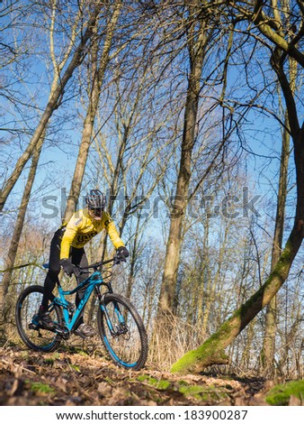 ALMERE, NETHERLANDS - FEB. 3, 2014: Mountain biker test riding a brand new  state of the art mountainbike in a Dutch forest to assess whether it provides a smooth and easy ride on rough terrain