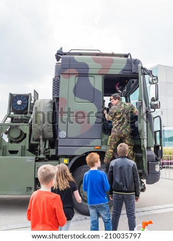 ALMERE, NETHERLANDS - 23 APRIL 2014: Dutch military tow truck on display during the National Army Day in Almere can be inspected by the general public, including unidentified children,  at close range