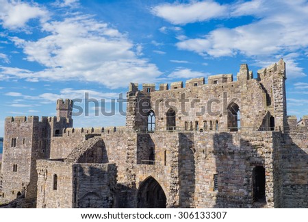 CAERNARFON, WALES - 29 SEPT. 2013: View on the walls and towers of Caernarfon Castle. The castle is a major landmark in Wales and attracts thousands of tourists each year