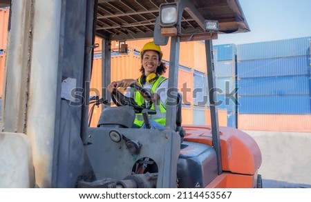 Female foreman wears safety hard hat is driving heavy lifting forklift at shipping container yard. Smiling African American industrial engineer woman drives reach stacker truck at cargo warehouse port Photo stock © 