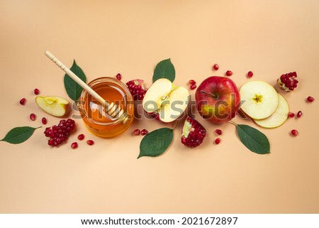 Traditional Jewish holiday New Year. Happy Rosh Hashanah. Apples, pomegranates and honey on a yellow background. Place for your text.