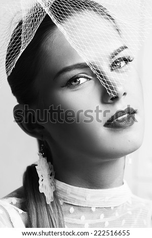 Beautiful woman with stylish hat and elegant white dotted blouse looking forward. Hair style. High fashion model. Portrait of young woman. Beautiful lady. Black and white