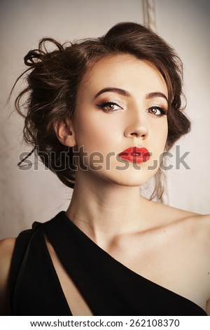 Portrait of young elegant lady with brown hair and beautiful hairstyle. Young beautiful woman. Elegant portrait. Black dress. Stylish woman.