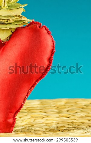 half of red heart decoration on background made of dry banana leaf with circle texture and turquoise color