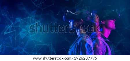 Teenager having fun play metaverse VR virtual reality glasses sport game 3D cyber space futuristic neon colorful background, future digital technology game and entertainment