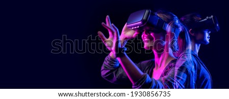 Future digital technology metaverse game and entertainment, Teenager having fun play VR virtual reality goggle, sport game 3D cyber space futuristic neon colorful background,  商業照片 © 