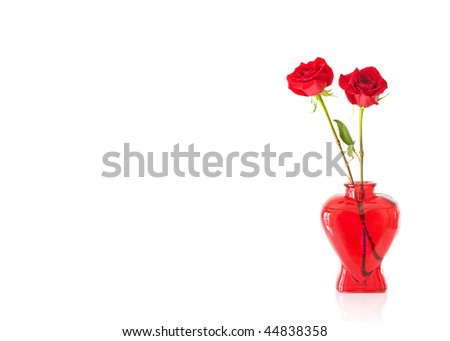 2 long stem red roses in a red glass heart shaped vase isolated on white with text/copy space