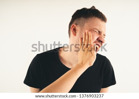 Crop person slapping scared man in face. Emotional male getting slapped in face while shouting with closed eyes in fear on white background Stock fotó © 