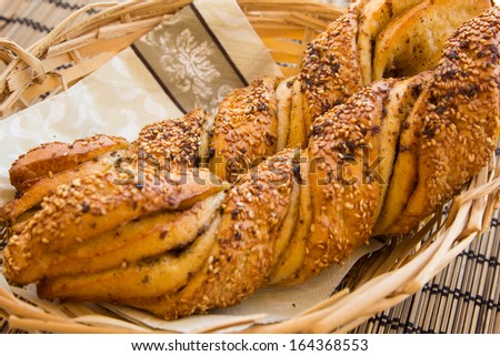 Breakfast still life with twisted bread with garlic and sesame seeds in a wicker basket