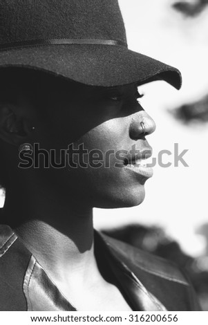 Close up Fashionable Young African Woman Looking to the Right of the Frame with a Smiling Face in a Monochrome Color.