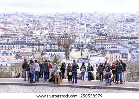 Paris, France - January 11, 2015. View  on  Paris from Montmartre hill. Tourists enjoying view to the city.  Montmartre is one of the most popular destinations in Paris. Winter day. Travel concept.
