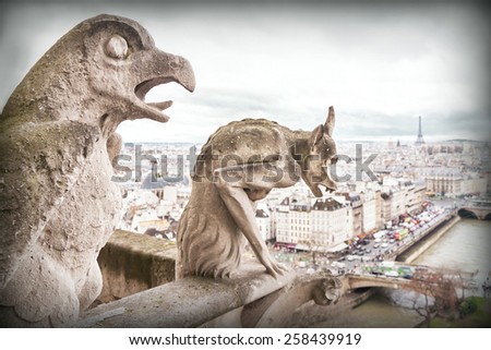 Gargoyle (chimera), famous stone demons, with Paris city on background. View from the tower of the Notre Dame de Paris cathedral. France. Travel, architecture concept. Copy space. Place for your text.