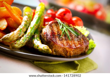 Grilled Beef Steak Meat with Fried Potato, Asparagus and Cherry Tomato. Steak Dinner. Food. BBQ Grill. Berbecue
