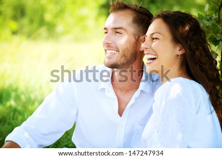 Happy Couple Outdoor. Smiling Couple Relaxing in a Park. Family over Nature Green Background. Smiling Man and Woman Having Picnic in Countryside. Relationships