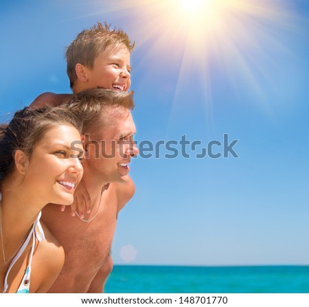 Happy Young Family with Little Child Having Fun at the Beach. Joyful Family. Travel and Vacation Concept. Summer Holidays