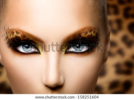 Beauty Fashion Model Girl with Holiday Leopard Makeup. Golden Wild Cat Eyes Make-up Eyeshadow. Beautiful Woman Face with Perfect skin. Animal Make up