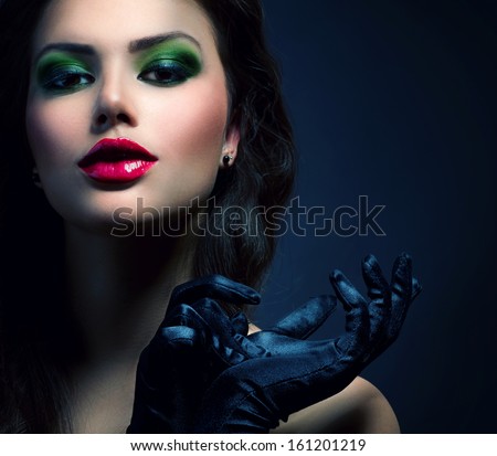 Beauty Fashion Glamour Girl Portrait. Vintage Style Model Girl Wearing Gloves. Holiday Glamour Make-up. Red Lipstick and Deep Green Eyeshadows. Darkness. Beautiful Mysterious Woman Dark Portrait